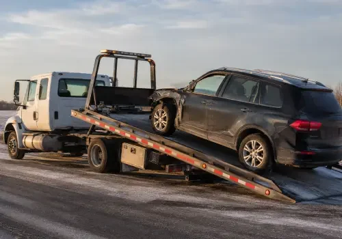 Tow truck transporting machinery and recovering a disabled vehicle in Calgary